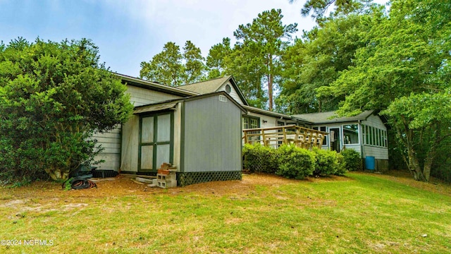 view of property exterior featuring a sunroom and a lawn