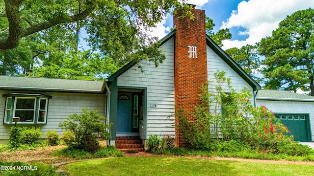 view of front of house with a garage and a front lawn