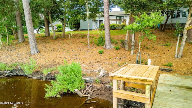 view of yard with a deck with water view