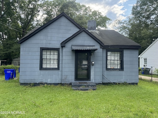 bungalow-style home with a front yard