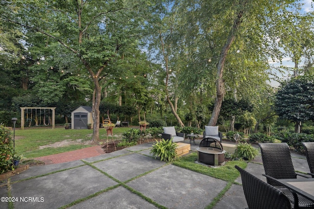 view of patio / terrace featuring an outdoor fire pit, an outdoor structure, and a storage unit