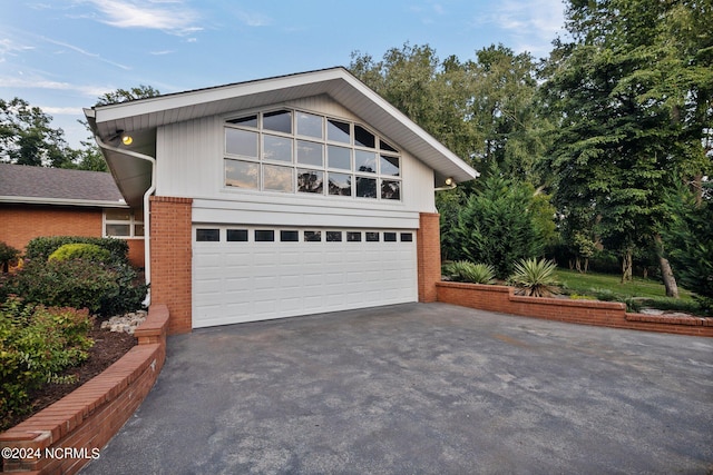 view of front of home featuring brick siding, driveway, and an attached garage