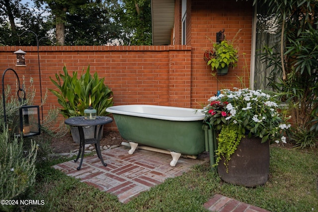 bathroom with a freestanding bath and brick floor