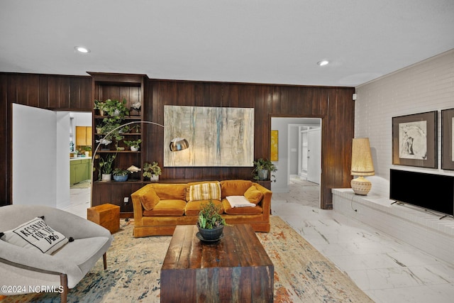 living room featuring marble finish floor, recessed lighting, and wooden walls