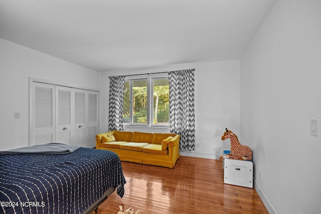 bedroom with a closet, baseboards, and wood finished floors