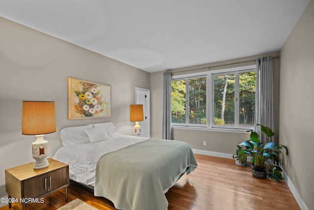 bedroom with baseboards and wood finished floors