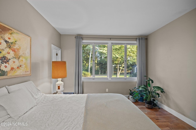 bedroom featuring baseboards and wood finished floors