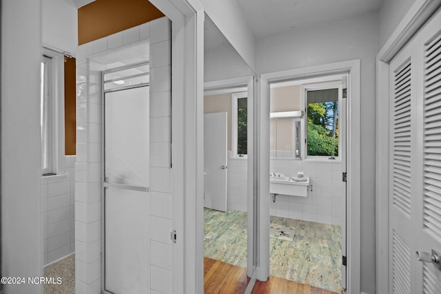 bathroom with tile walls and wood finished floors