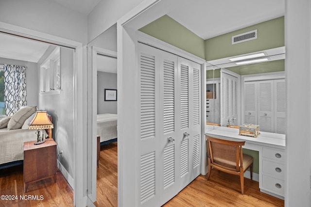 ensuite bathroom with baseboards, visible vents, connected bathroom, and wood finished floors