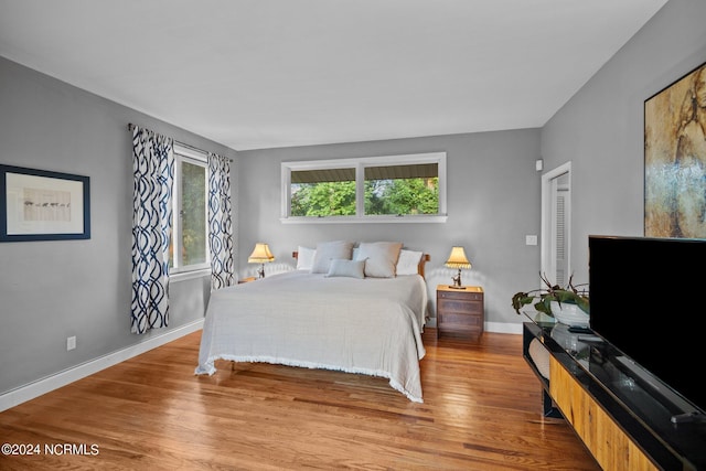 bedroom featuring baseboards and wood finished floors