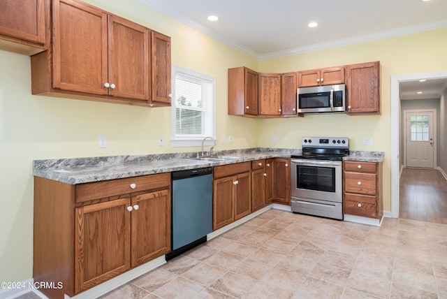 kitchen with sink, appliances with stainless steel finishes, a wealth of natural light, and light tile patterned floors