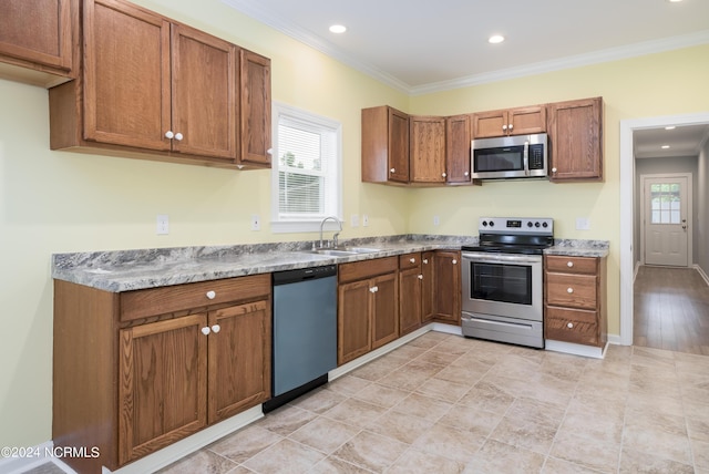 kitchen featuring a healthy amount of sunlight, appliances with stainless steel finishes, brown cabinets, and a sink