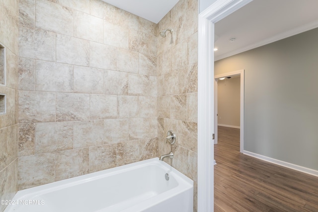 full bathroom with baseboards, wood finished floors, and bathing tub / shower combination