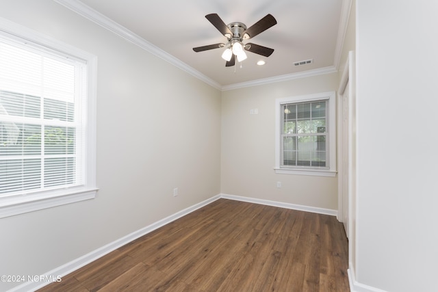 spare room with dark wood-style floors, a healthy amount of sunlight, and visible vents