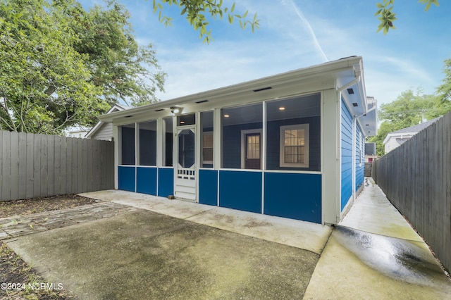 view of front of house featuring a sunroom and a fenced backyard