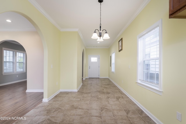 doorway with a healthy amount of sunlight, baseboards, and crown molding