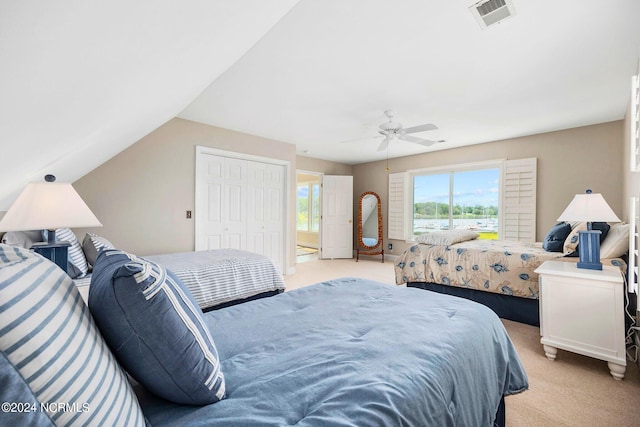 carpeted bedroom with vaulted ceiling, ceiling fan, and a closet