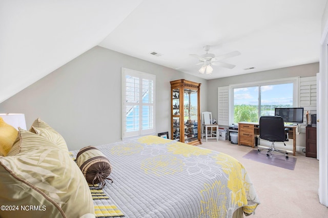 bedroom with ceiling fan, vaulted ceiling, and light carpet