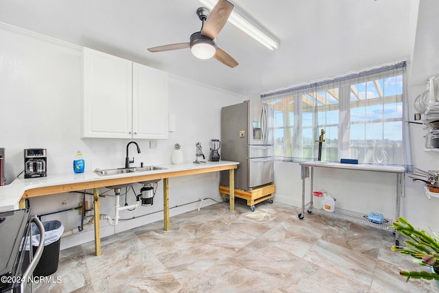 kitchen with sink, stainless steel fridge, ceiling fan, ornamental molding, and white cabinets