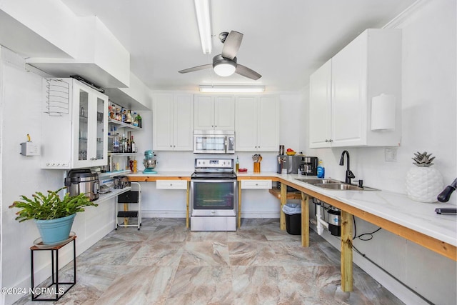 kitchen featuring sink, white cabinets, ceiling fan, stainless steel appliances, and light stone countertops