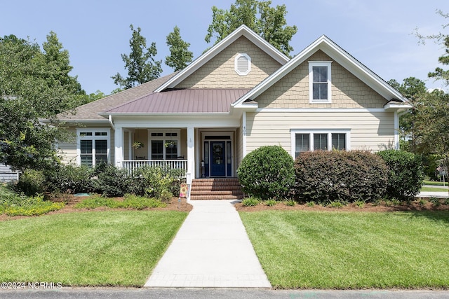 craftsman house featuring a standing seam roof, metal roof, a porch, and a front yard