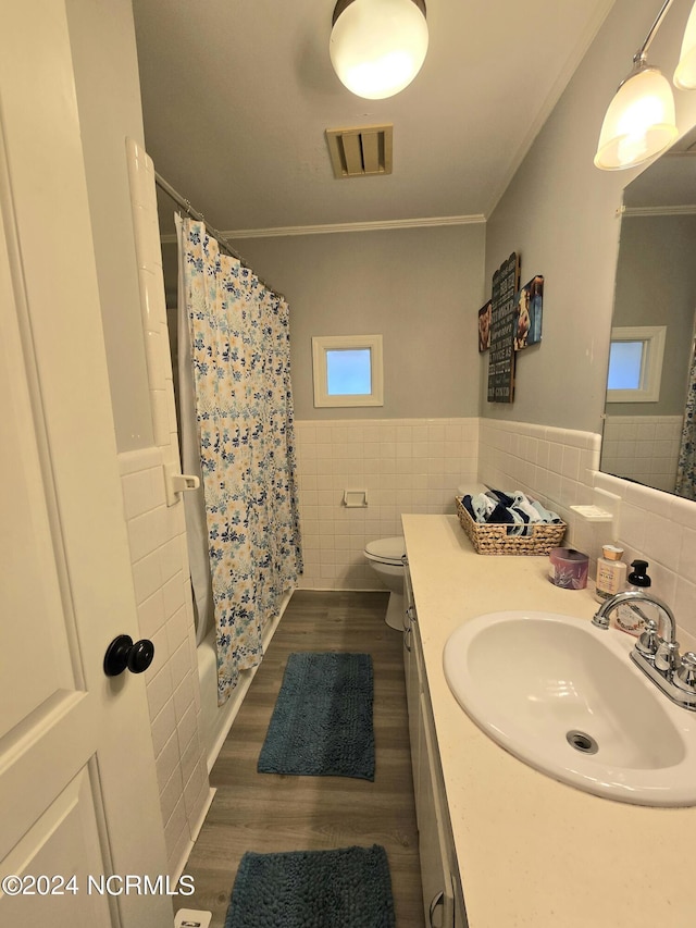 full bathroom featuring ornamental molding, toilet, and tile walls