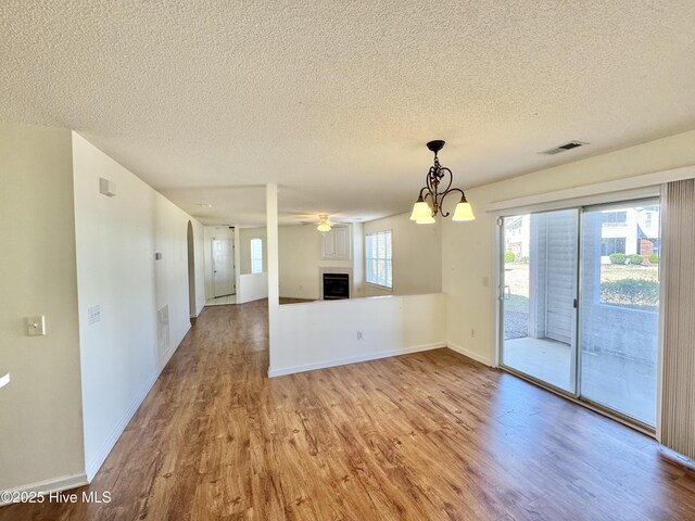 living room featuring ceiling fan, hardwood / wood-style floors, a textured ceiling, and a fireplace