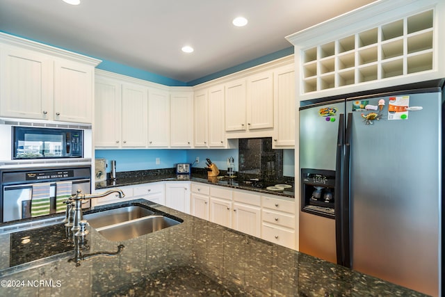 kitchen with dark stone countertops, sink, stainless steel appliances, and white cabinetry