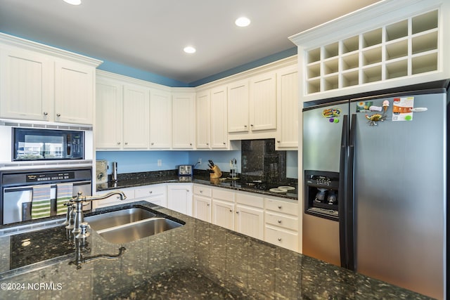 kitchen featuring white cabinetry, sink, dark stone counters, and black appliances