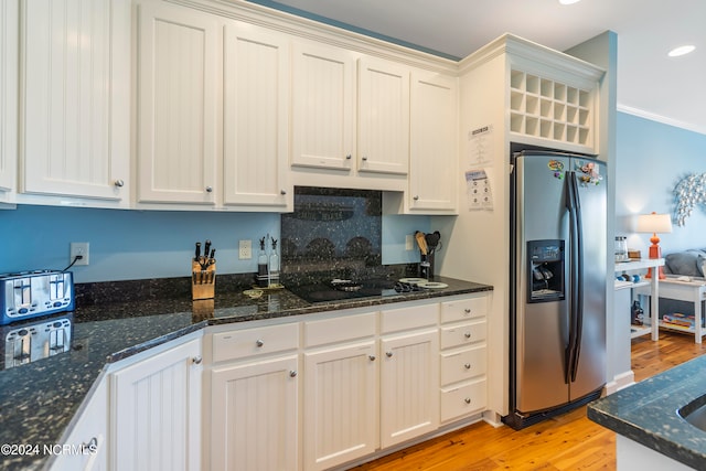 kitchen featuring dark stone counters, light hardwood / wood-style flooring, and stainless steel refrigerator with ice dispenser