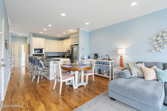 dining room with sink and light wood-type flooring