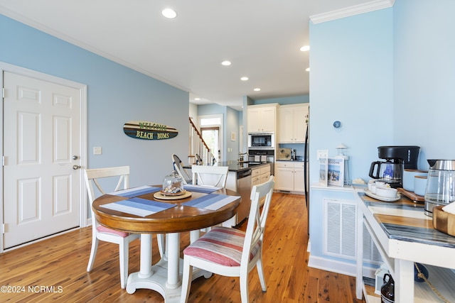 dining room featuring crown molding and light hardwood / wood-style flooring