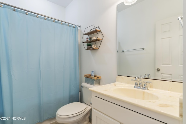 bathroom featuring vanity, toilet, and curtained shower