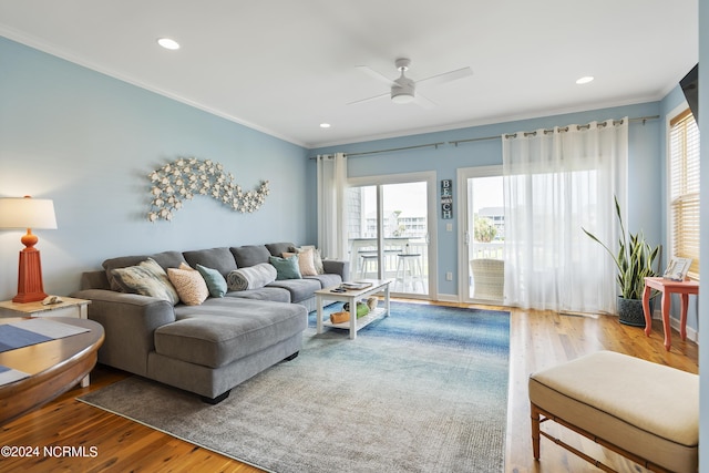 living room with ceiling fan, a healthy amount of sunlight, ornamental molding, and hardwood / wood-style floors