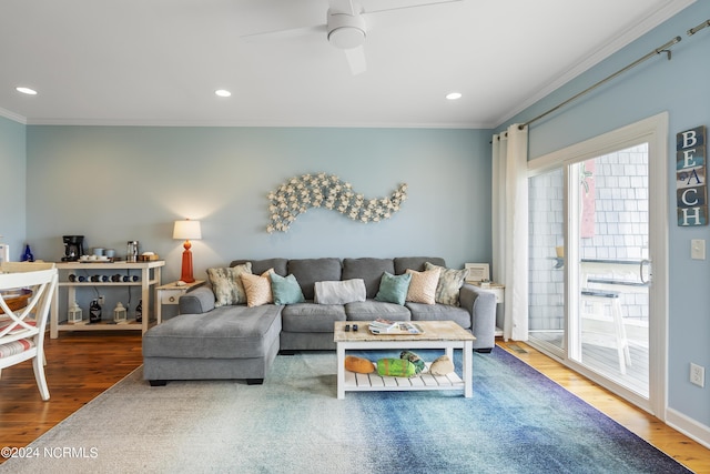 living room with hardwood / wood-style floors, ornamental molding, and ceiling fan