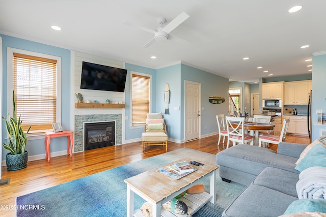 living room with plenty of natural light, ceiling fan, light hardwood / wood-style flooring, and ornamental molding