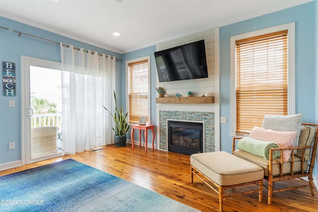 living room with hardwood / wood-style flooring, a wealth of natural light, and ornamental molding