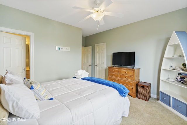 bedroom featuring light colored carpet, ceiling fan, and a closet