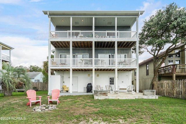 back of property featuring a balcony, a patio area, and a yard