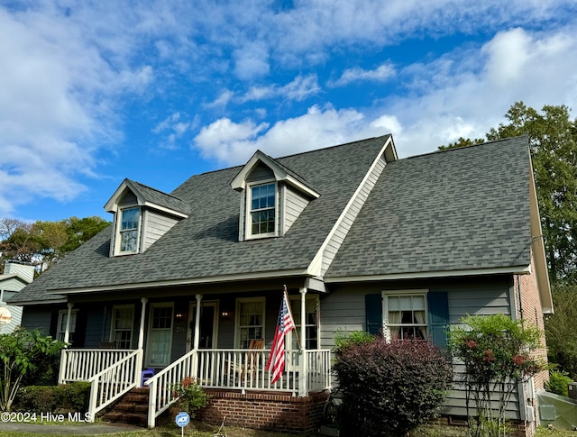 cape cod-style house with a porch and a front yard