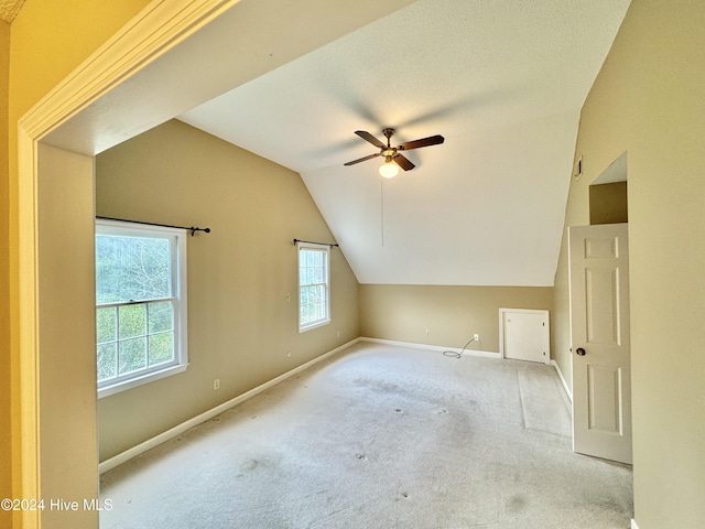 bonus room featuring lofted ceiling, ceiling fan, light carpet, and baseboards