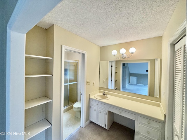 bathroom with toilet, a textured ceiling, vanity, and a stall shower