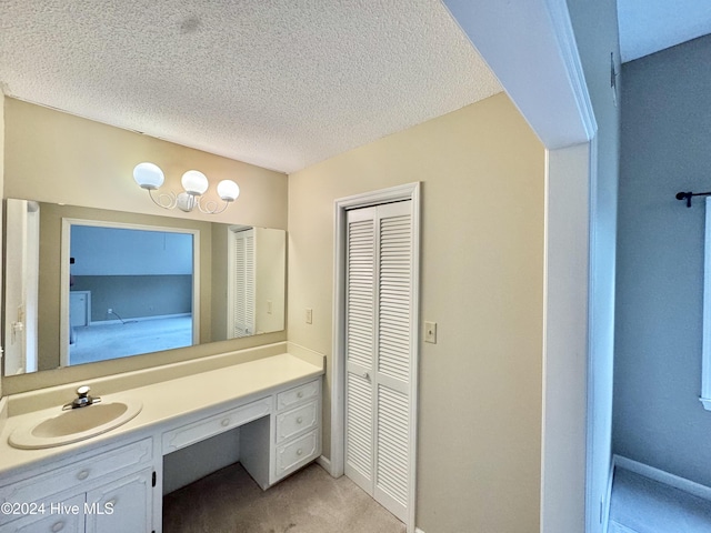 bathroom featuring baseboards, a textured ceiling, and vanity