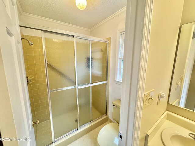 bathroom featuring a shower with door, vanity, a textured ceiling, and toilet