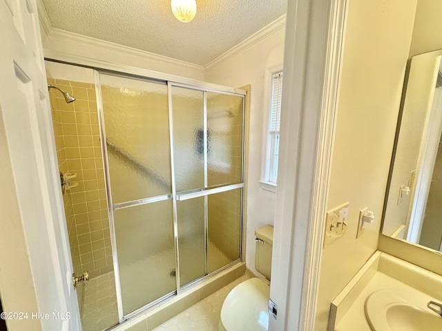 full bath with a textured ceiling, toilet, vanity, ornamental molding, and a stall shower