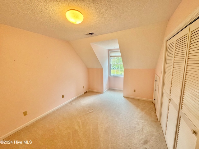 unfurnished bedroom featuring a textured ceiling, crown molding, carpet, and a closet