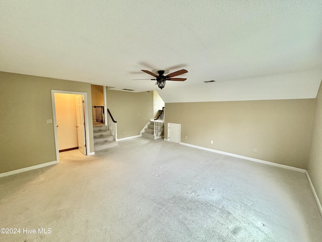 unfurnished room with baseboards, visible vents, ceiling fan, stairs, and a textured ceiling