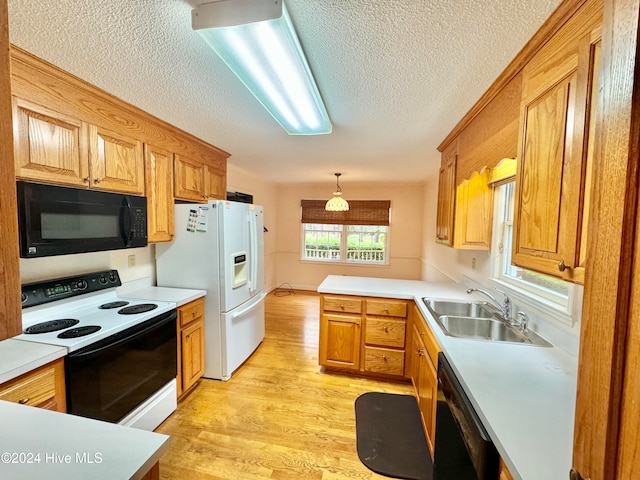 kitchen with black appliances, sink, light hardwood / wood-style flooring, a textured ceiling, and decorative light fixtures