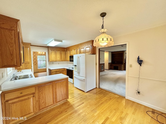 kitchen featuring white refrigerator with ice dispenser, a peninsula, light countertops, pendant lighting, and a sink