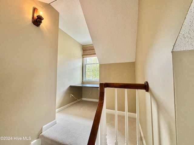 stairs with carpet flooring and a textured ceiling